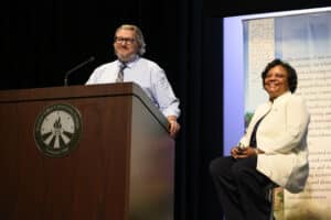 Troy Swanson and Dr. Sylvia Jenkins are on a stage together