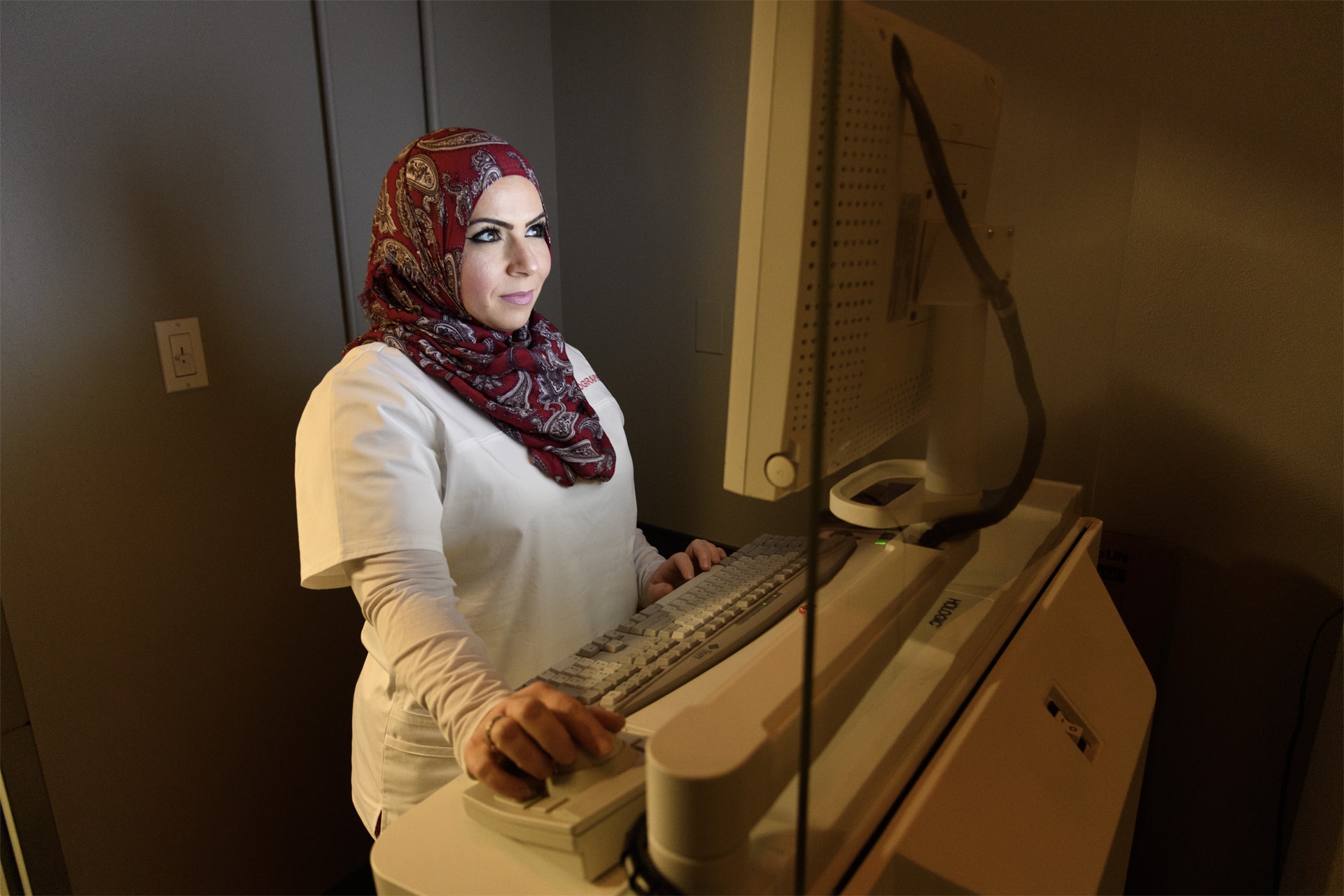 Woman standing with a mammography machine 