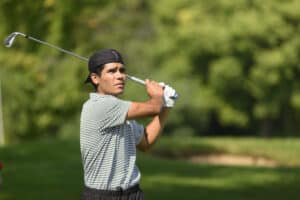 A golfer watches after finishing his swing