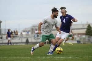 Men's soccer player dribbles the ball