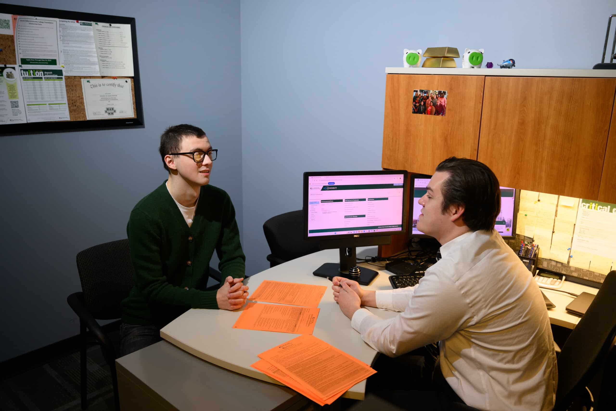 A student sitting in financial aid receiving advise from and advisor.