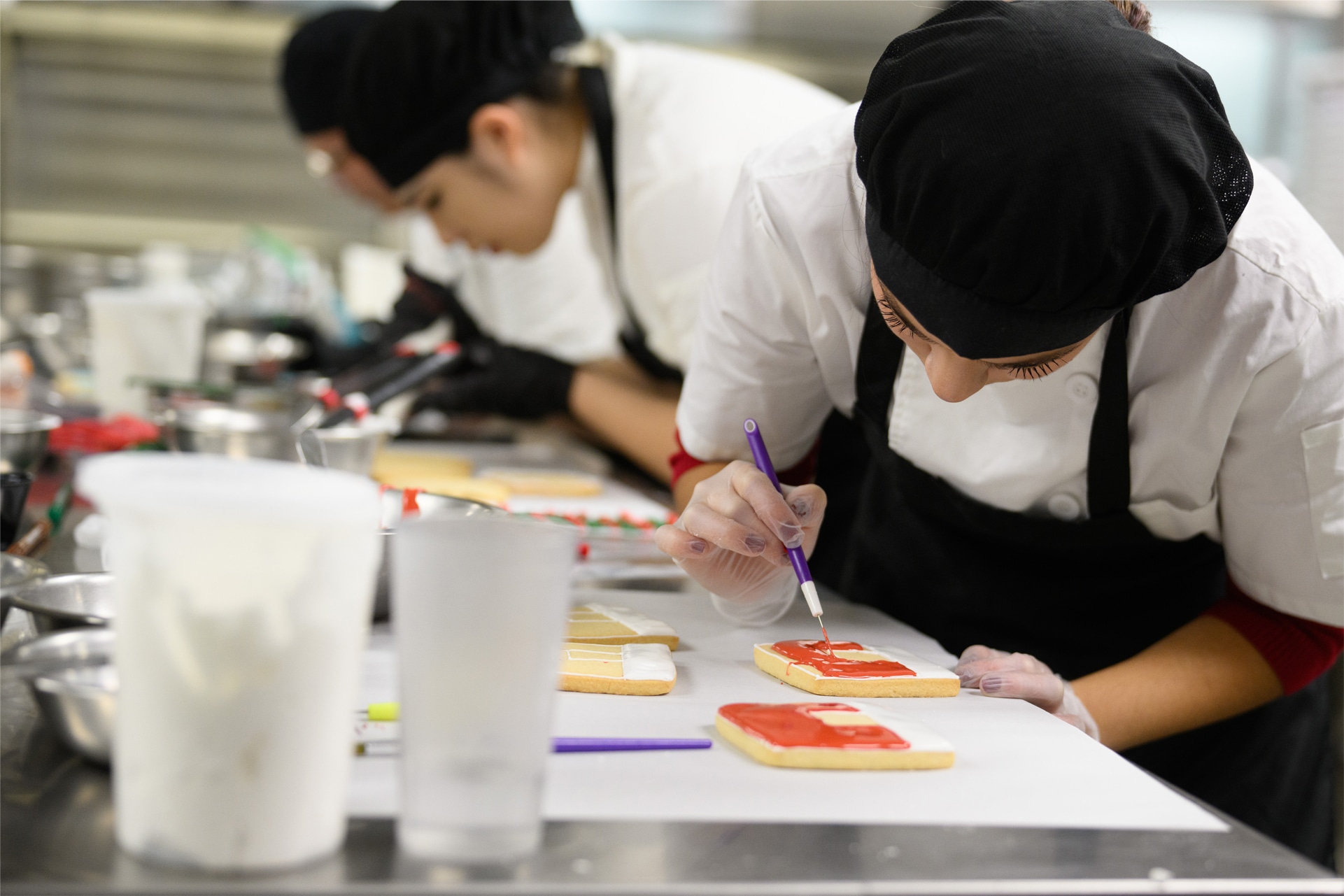 two culinary students working on cookie decorating