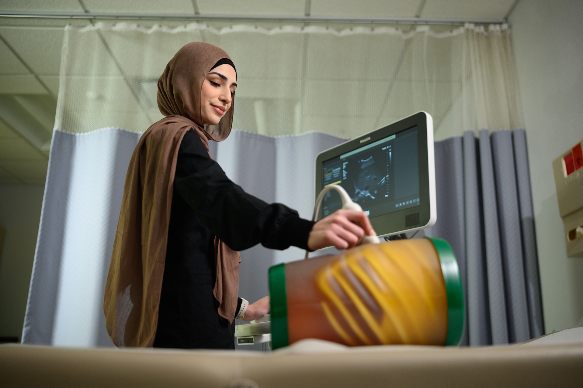 woman using a sonography machine in a classroom