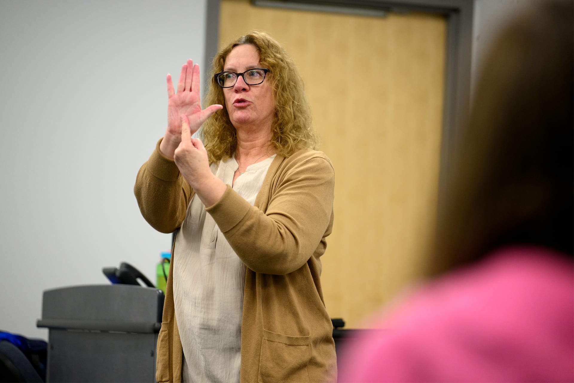 Female faculty member signing ASL in classroom