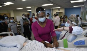 A nursing student wears a surgical mask and face shield as a professor talks her through lab work at the Education Center at Blue Island campus.